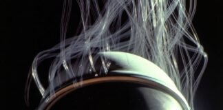 Inside Apollo 11: The Science and Technology Behind the Mission Neil Armstrong's visor faintly reflecting a tiny distorted Earth